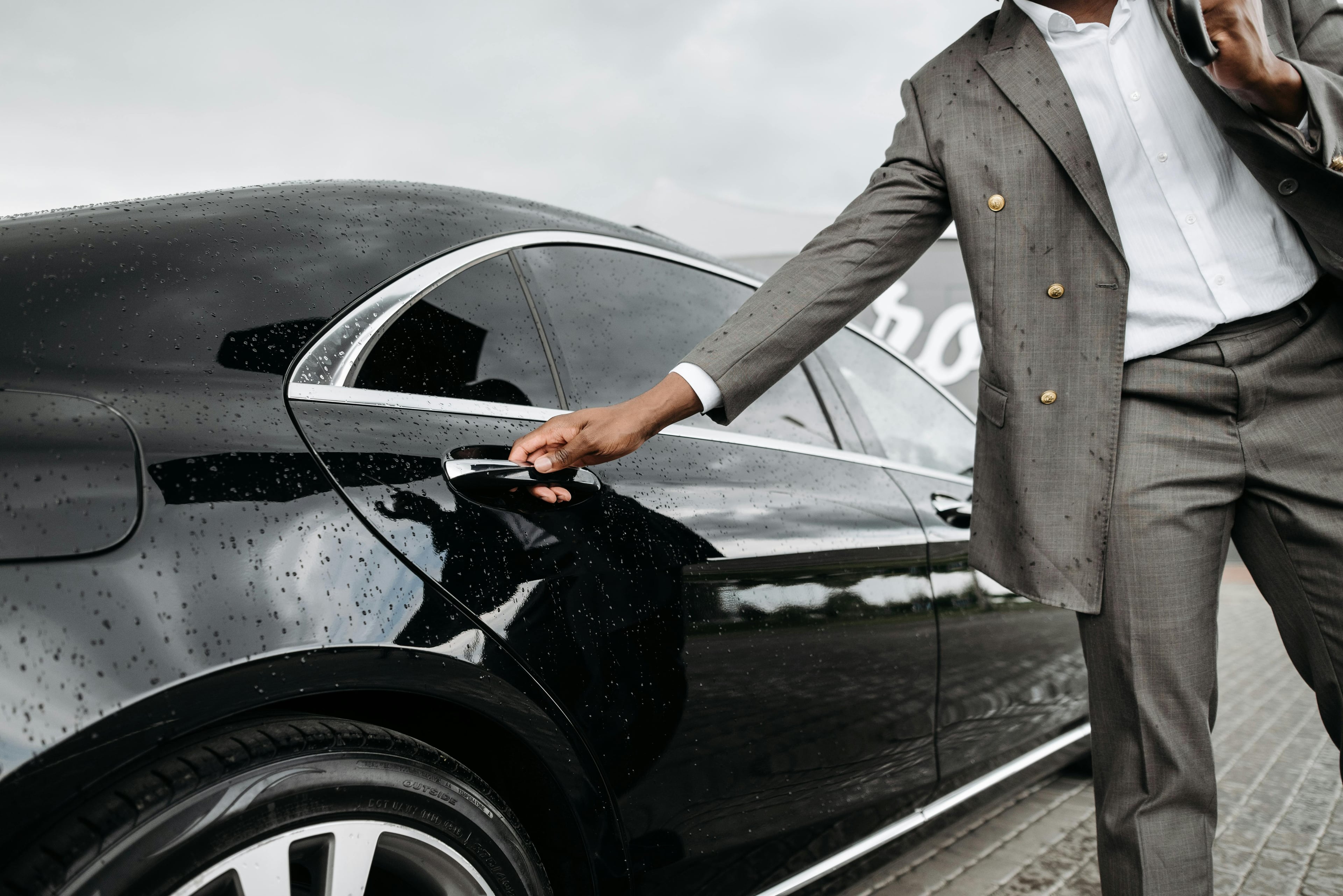 Professional chauffeur opening luxury car door